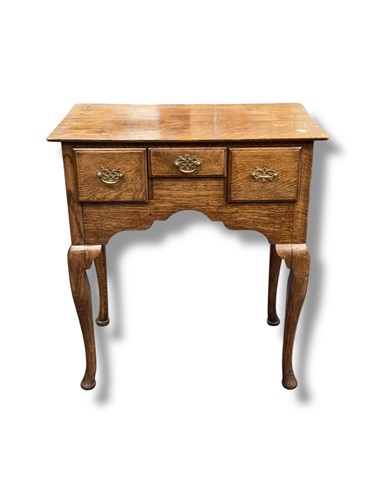 Lot 695 - A George III oak lowboy with three frieze...