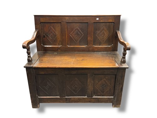 Lot 686 - An oak box settle with lozenge carved panels...