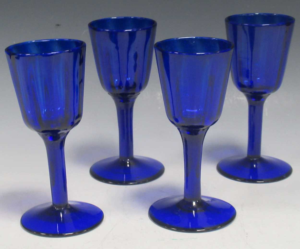 Lot 9 - A set of four blue glass fluted wine glasses,...