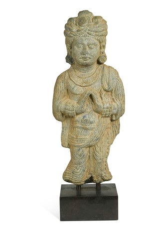 Lot 110 - A Gandharan style carved grey schist standing figure of a man wearing a turban