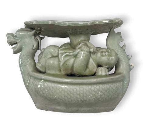 Lot 85 - A Japanese celadon porcelain dragon boat and boy's pillow, late 19th century