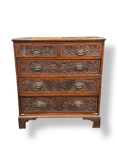Lot 550 - A George II and later carved oak chest of drawers
