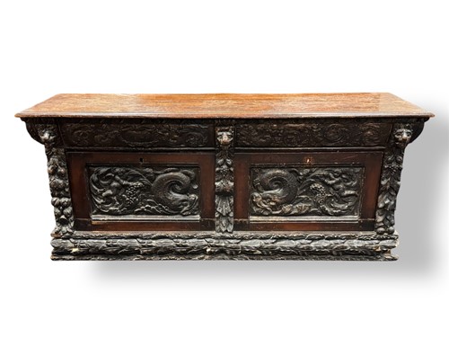 Lot 552 - A Continental oak low cupboard with dolphin...