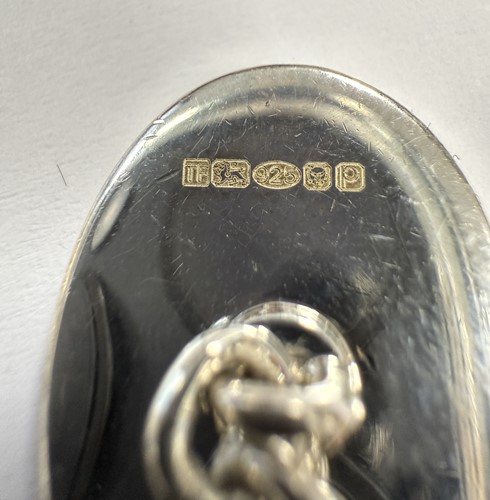 Lot 303 - Theo Fennell - A silver keyring and a pair of silver and enamel cuff links