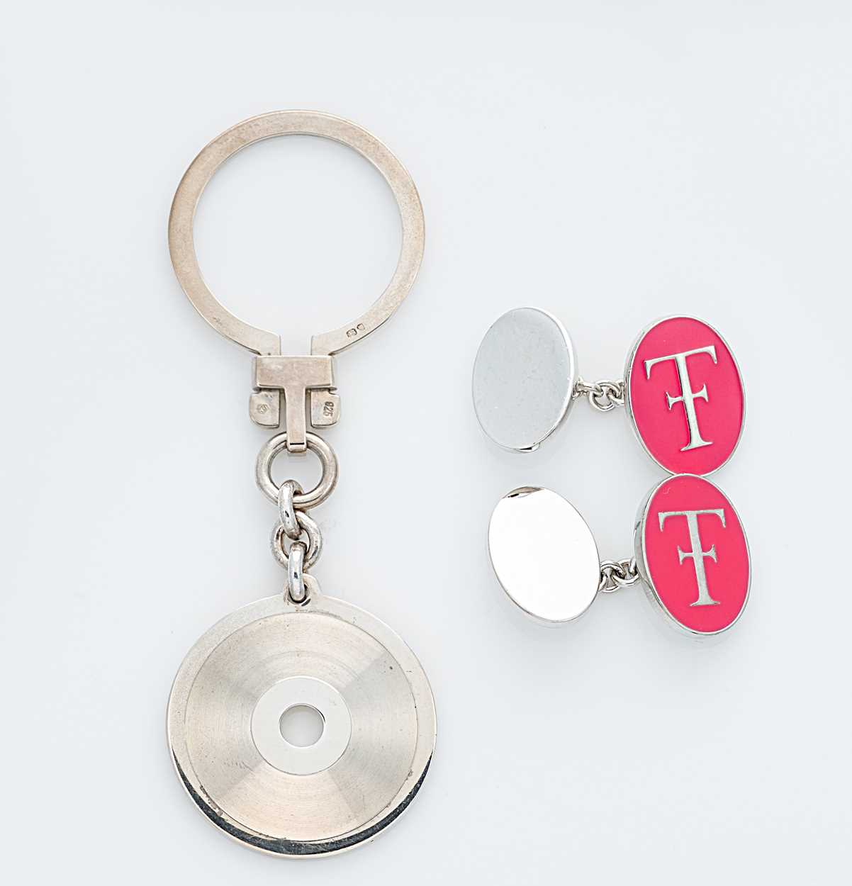 Lot 303 - Theo Fennell - A silver keyring and a pair of silver and enamel cuff links