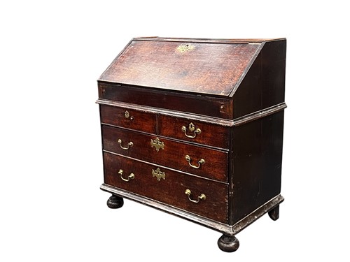 Lot 630 - An early 18th century oak slope front bureau,...