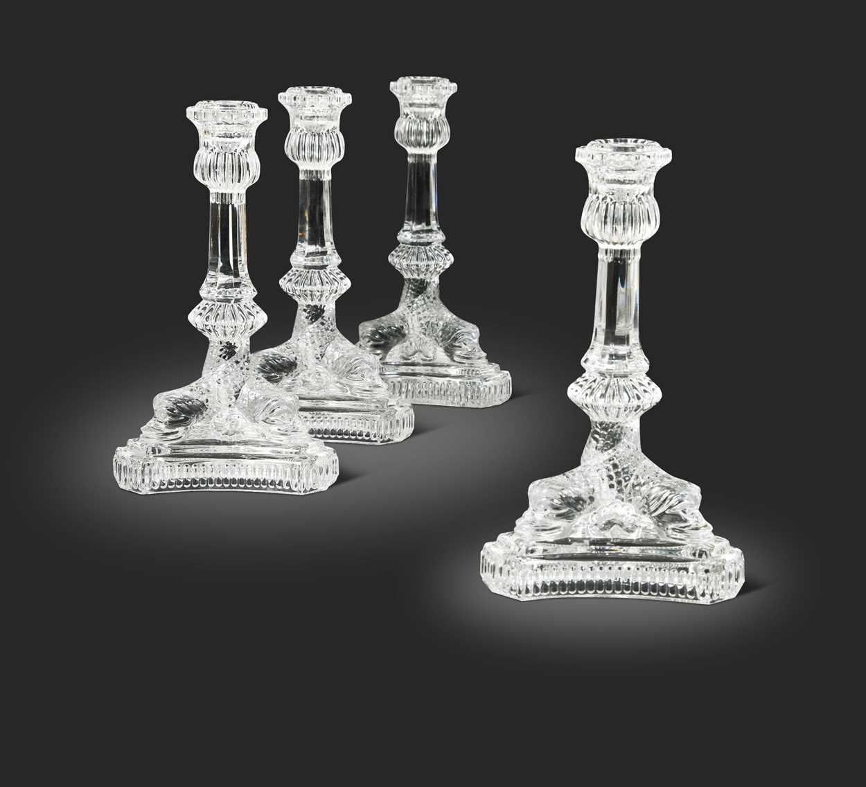 Lot 3 - Tiffany & Co., a group of four polished glass 'dolphin' candlesticks