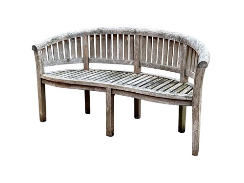 Lot 777 - A 20th century curved teak slatted garden...