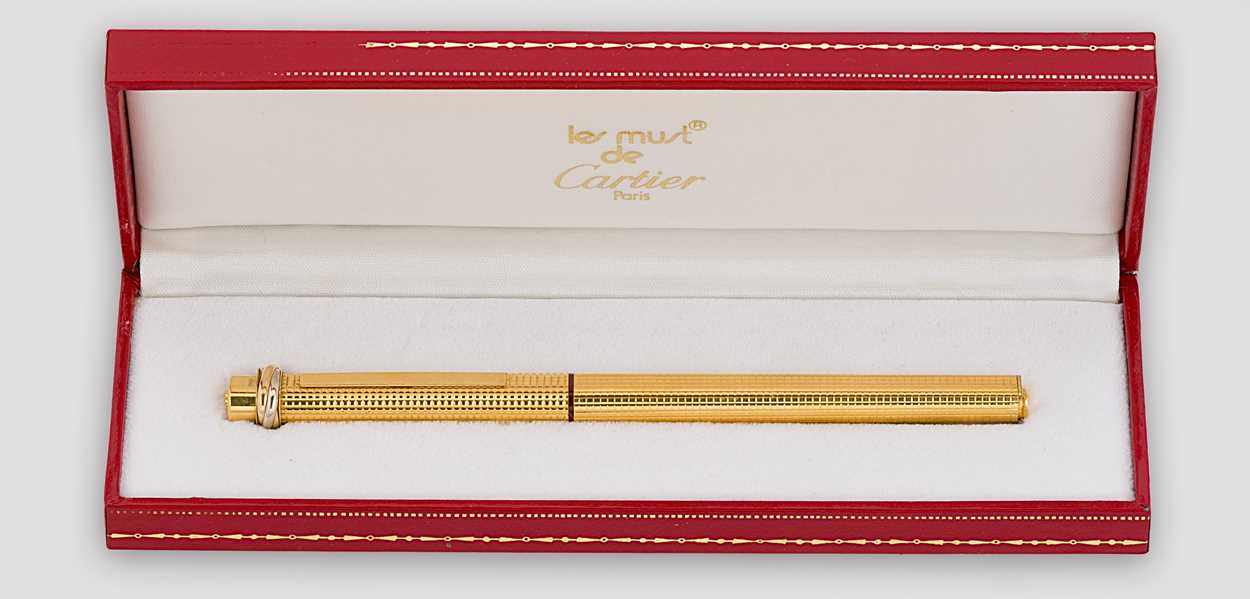 Lot 322 - Cartier - A 'Les Must de Cartier Trinity' gold-plated rollerball pen case