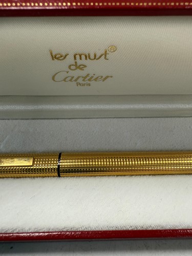 Lot 322 - Cartier - A 'Les Must de Cartier Trinity' gold-plated rollerball pen case