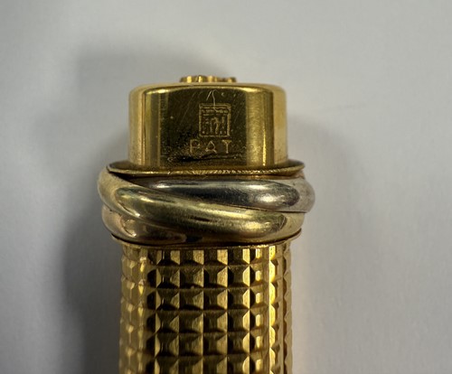 Lot 322 - Cartier - A 'Les Must de Cartier Trinity' gold-plated rollerball pen case