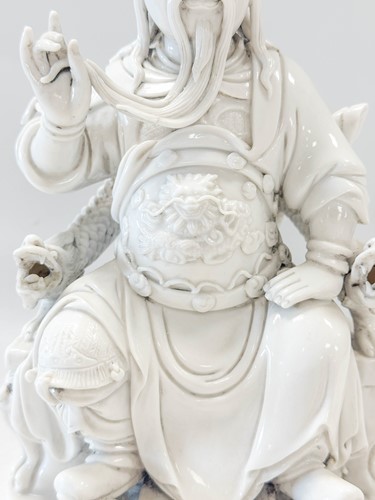 Lot 48 - A Dehua seated figure of Guandi, Daoist God of War, mark of He Chaozong