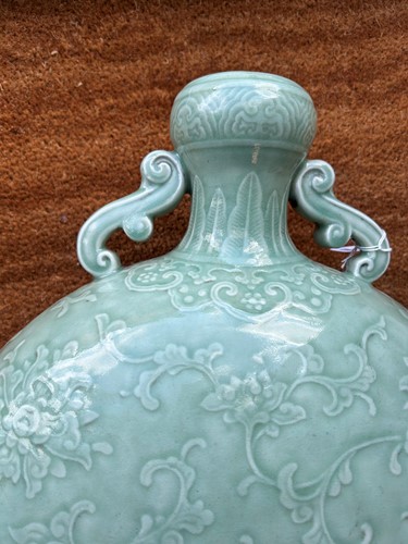 Lot 14 - A Chinese celadon glazed and carved large moonflask, Qing Dynasty, 18th century