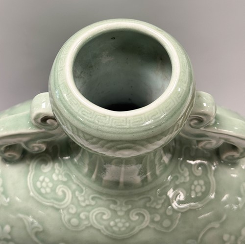 Lot 14 - A Chinese celadon glazed and carved large moonflask, Qing Dynasty, 18th century