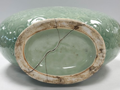 Lot 14 - A Chinese celadon glazed and carved large moonflask, Qing Dynasty, 18th century