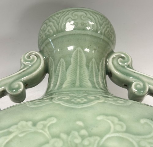 Lot 14 - A Chinese celadon glazed and carved large moonflask, Qing Dynasty, 18th century