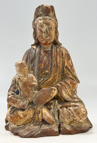 Lot 70 - A Chinese carved and gilded wood figure of Guanyin with child, late Ming/early Qing Dynasty