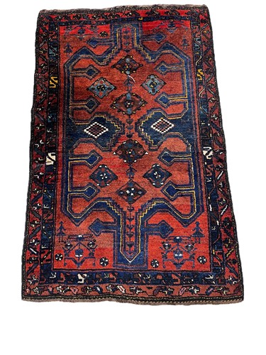 Lot 699 - A 20th century tribal wool rug, rust ground...