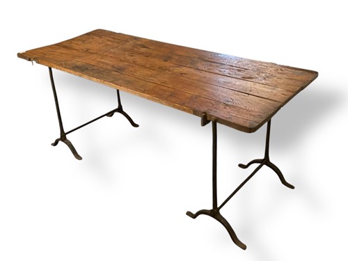 Lot 687 - A plank top trestle table, on iron end supports