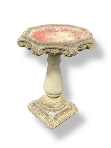 Lot 554 - A reconstituted stone bird bath with shape top,...
