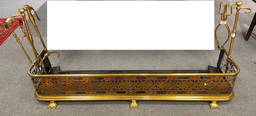 Lot 235 - A pierced brass fender with companion brass...