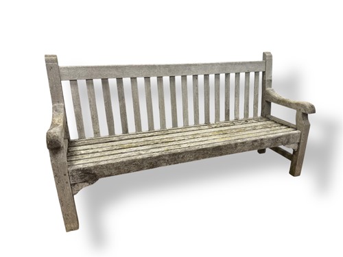 Lot 716 - A teak three seater garden bench with slatted...