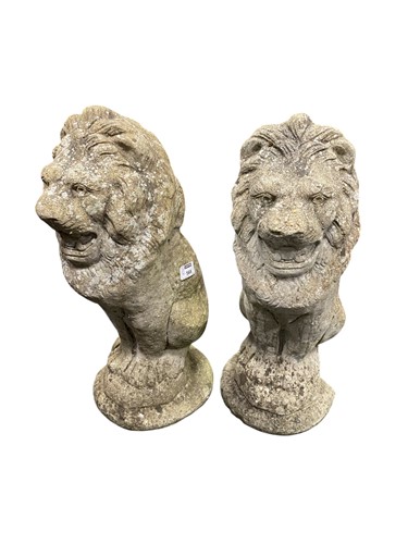 Lot 568 - A pair of composite stone lion sejant figures...