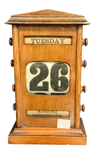 Lot 123 - A wooden and glazed perpetual calendar 23cm high