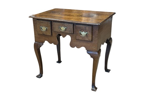 Lot 557 - An 18th century oak lowboy, with three drawers...