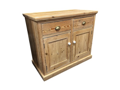 Lot 601 - A pine cupboard, two drawers with brass cup...