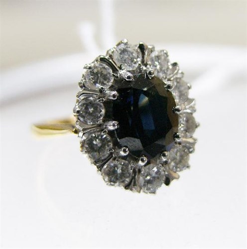 Lot 214 - An 18ct gold ring with sapphire and diamond cluster