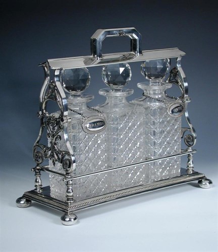 Lot 341 - An electroplate framed three bottle tantalus