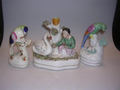 Lot 40 - Two Staffordshire parrot inkwells and a group of a boy feeding a swan