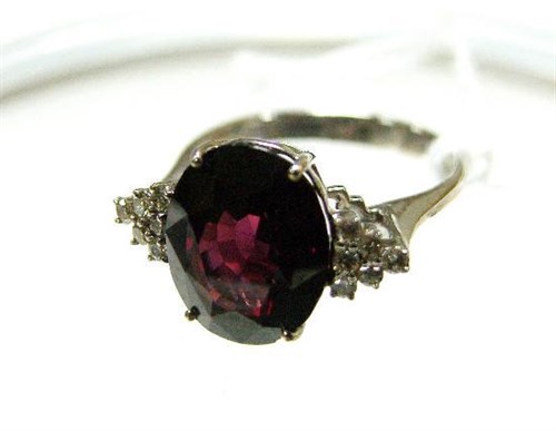 Lot 247 - An 18ct white gold garnet and diamond ring