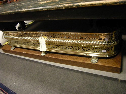 Lot 134 - A Victorian brass fire kerb and another in oak...