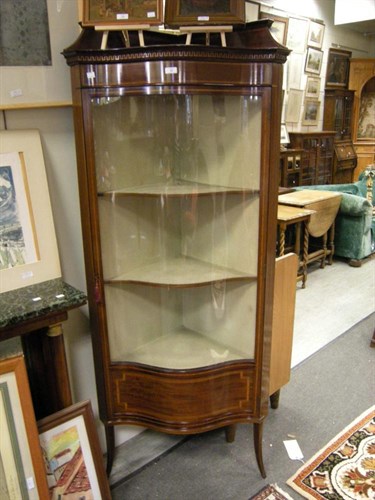 Lot 69 - An Edwardian mahogany serpentine corner cabinet