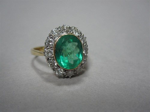 Lot 180 - An 18ct gold emerald and diamond cluster ring