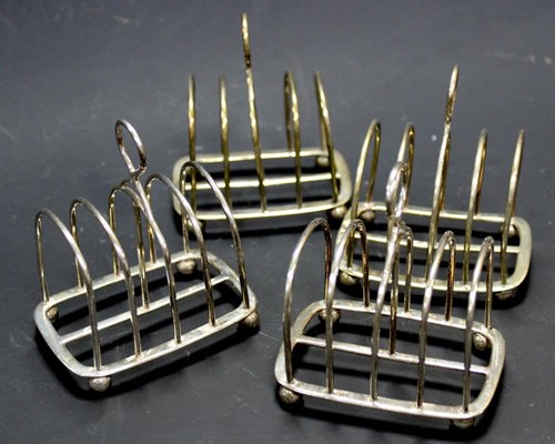 Lot 290 - A set of four silver five bar toastracks