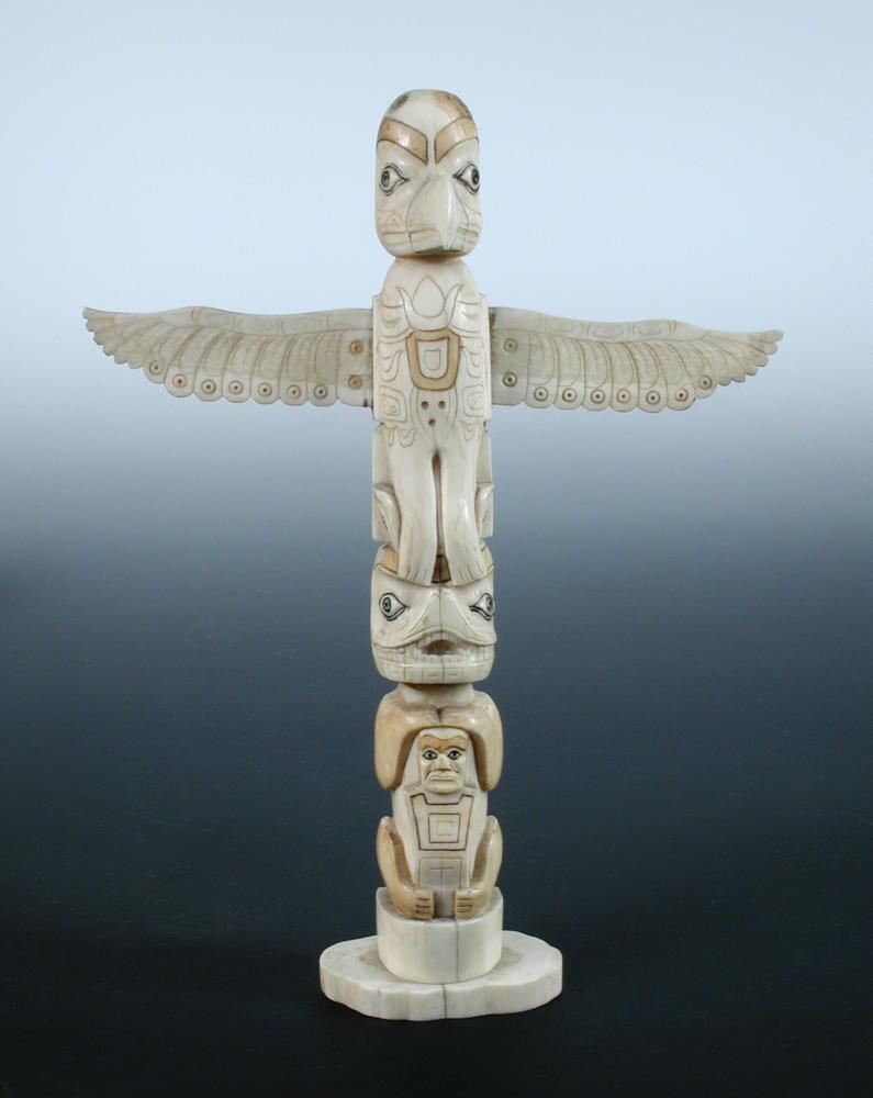 Lot 559 - A North West Coast native American walrus ivory totem
