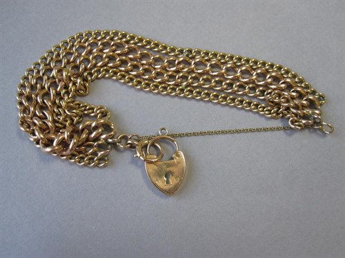 Lot 169 - A four row curb link bracelet with heart locket clasp