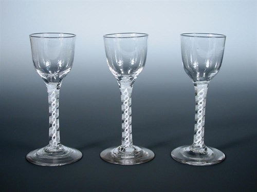 Lot 114 - A set of three 18th century double helix opaque twist stemmed wine glasses