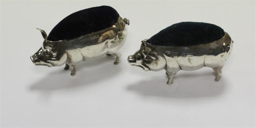 Lot 255 - A matched pair of silver pin cushions modelled as pigs