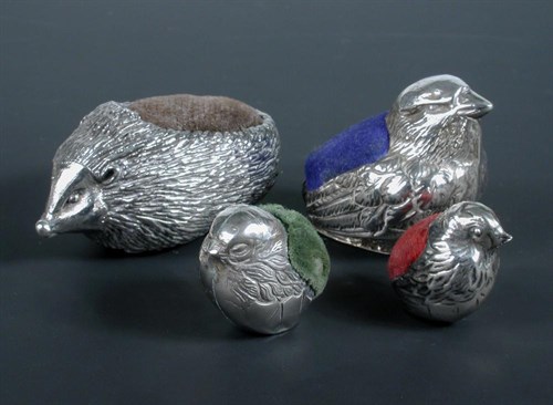 Lot 280 - A matched graduated set of three silver pincushions modelled as chicks