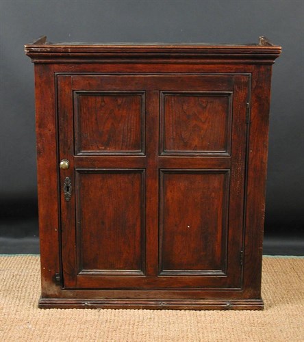 Lot 651 - An early 19th century elm wall cupboard