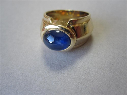 Lot 185 - A contemporary 18ct gold and cabochon sapphire ring
