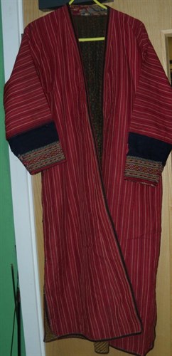 Lot 671 - A Persian striped red robe (shapan)