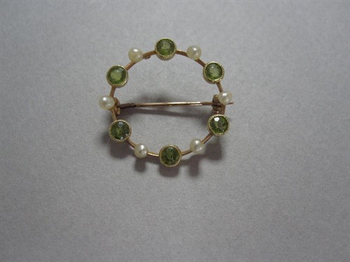 Lot 161 - A peridot and seed pearl hoop brooch