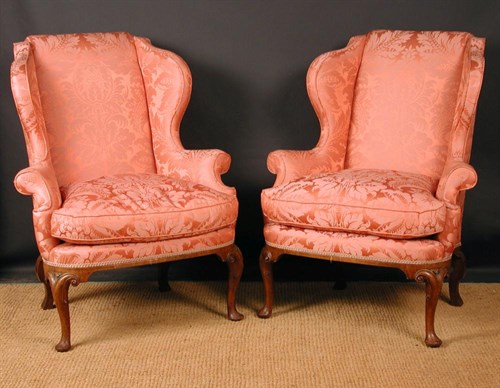Lot 797 - A pair of Queen Anne style walnut framed wing back armchairs