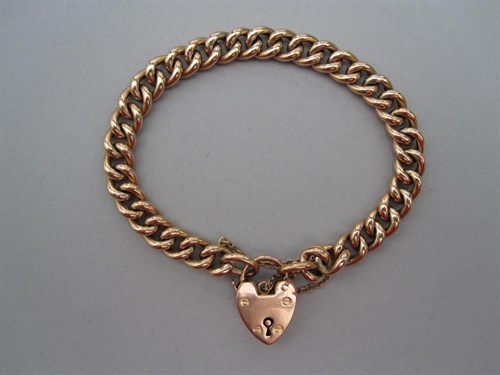 Lot 124 - A curb link bracelet with heart locket clasp