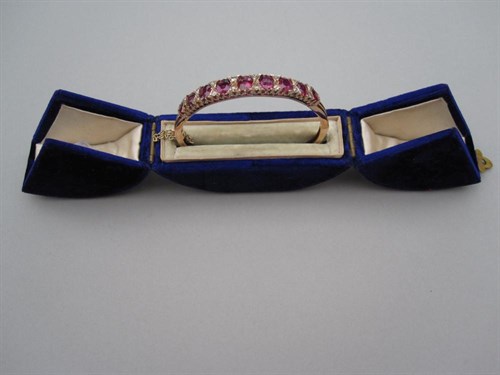 Lot 251 - An early 20th century ruby and diamond hinged bangle